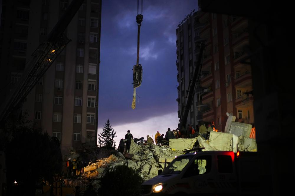 Emergency team members search for people in a destroyed building in Adana, Turkey, Tuesday, Feb. 7, 2023. Rescuers raced Tuesday to find survivors in the rubble of thousands of buildings brought down by a powerful earthquake and multiple aftershocks that struck eastern Turkey and neighbouring Syria. (AP Photo/Francisco Seco)