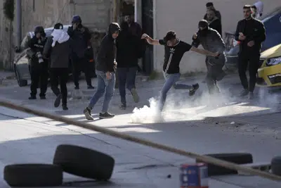 Un manifestante palestino patea una lata de gas lacrimógeno en enfrentamientos con fuerzas israelíes durante una redada en la ciudad cisjordana de Nablus, el lunes 3 de abril de 2023. (AP Foto/Majdi Mohammed)