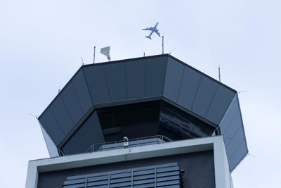 ARCHIVO - En esta fotografía de archivo del lunes 22 de abril de 2019, un avión vuela encima de la torre de control sur del Aeropuerto Internacional O'Hare de Chicago. (AP Foto/Kiichiro Sato, archivo)