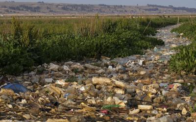 Botellas de plástico y basura flotan en el río Katari que desemboca en el lago Titicaca, en Chojasivi, Bolivia, el viernes 5 de 2021. (AP Foto / Juan Karita)