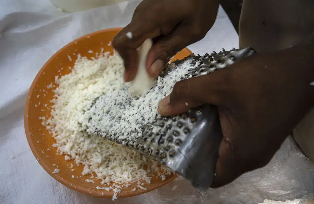 El productor de casabe Agustín Núnez ralla yuca para preparar el casabe, una especie de tortilla delgada y crujiente, en Quivicán, Cuba, el lunes 28 de mayo de 2023. El casabe está teniendo una etapa de resurgimiento en la isla, con promotores y restaurantes destacando sus beneficios como una alternativa sin gluten al pan. (AP Foto/Ramón Espinosa)