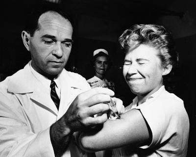 ARCHIVO - El Dr. Joseph Ballinger le dio a Marjorie Hill, una enfermera del Hospital Montefiore en Nueva York, la primera vacuna contra la gripe asiática que se administró en Nueva York el 16 de agosto de 1957. (AP Foto/Archivo)