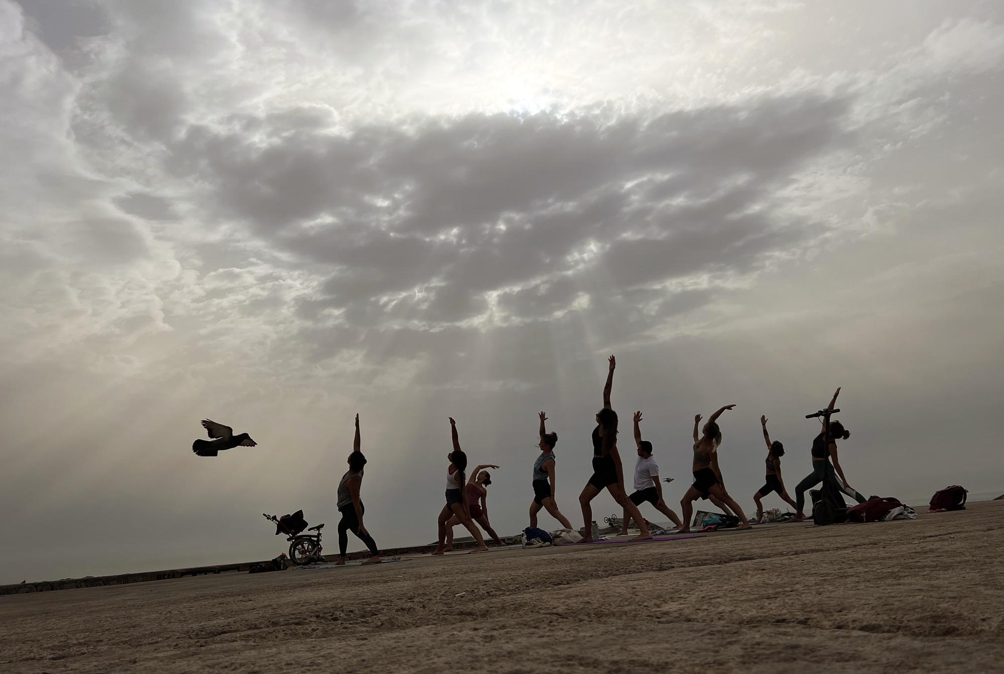 Men and women practice yoga on a breakwater by the Mediterranean Sea in Barcelona, Spain in this Tuesday, June 21, 2022 - iPhone photo. (Photo: Emilio Morenatti/AP)