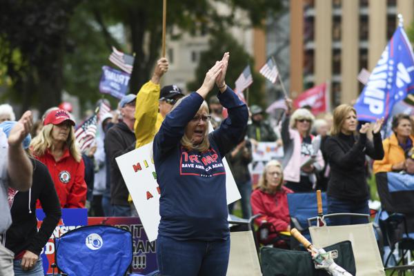 Rally-goers protest at the Michigan State Capitol Tuesday, Oct. 12, 2021, in Lansing, Mich. The event, organized by a group called Election Integrity Fund and Force, is demanding a "forensic audit" of the state's 2020 presidential election results. (Matthew Dae Smith/Lansing State Journal via AP)