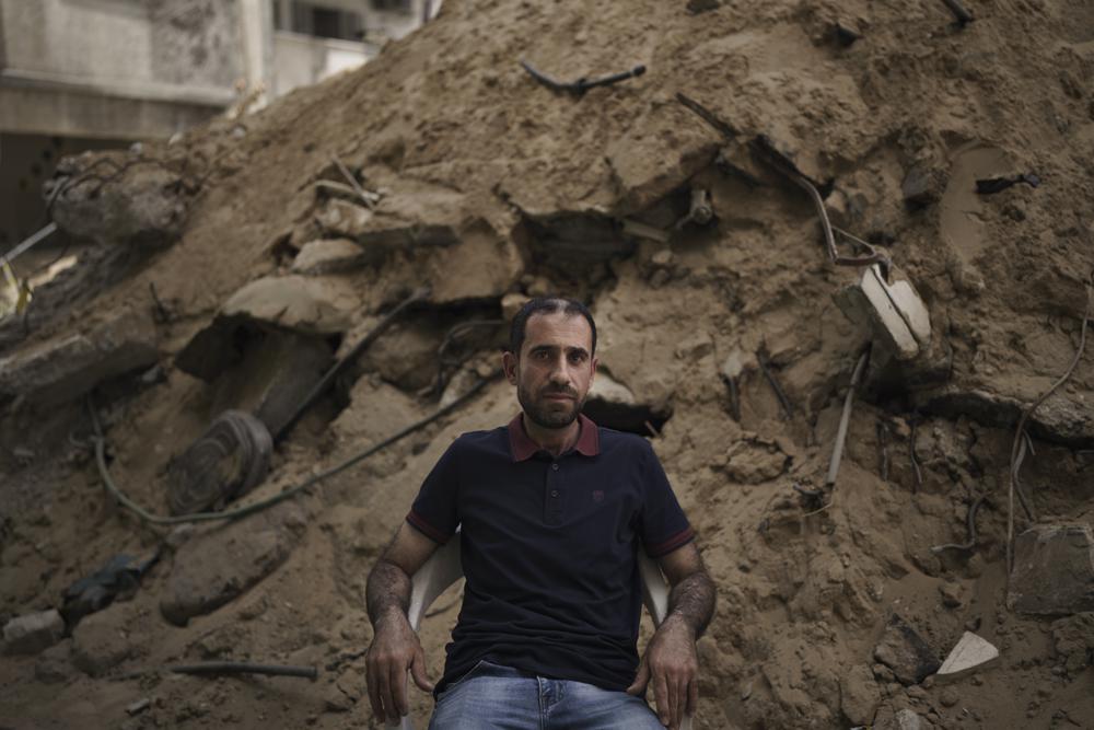 Azzam Al-Kawlak, 42, poses for photo next to the debris of his destroyed home in Gaza City, Monday, May 31, 2021. Azzam lost 22 relatives in the deadliest airstrike during the 11-day war between Gaza's Hamas rulers and Israel. (AP Photo/Felipe Dana)