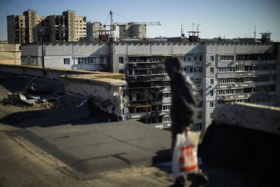 Un residente camina en el techo de un edificio dañado en el distrito de Saltivka, en el norte de Járkiv, Ucrania, el sábado 15 de octubre de 2022. (AP Foto/Francisco Seco)