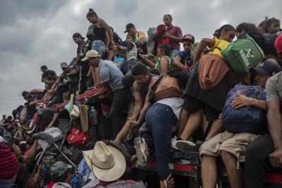 Migrantes ayudan a otros migrantes a subir a un tráiler el miércoles 17 de noviembre de 2021 en el municipio de Jesús Carranza, en el estado mexicano de Veracruz.  (AP Foto / Félix Márquez)