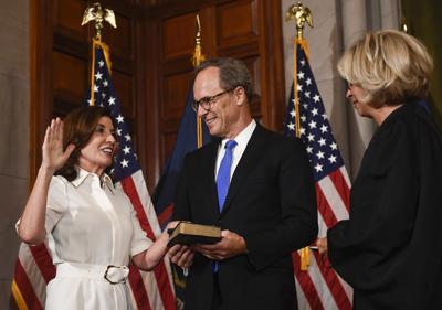 Kathy Hochul juramenta como gobernadora del estado de Nueva York, en una ceremonia en el Capitolio estatal el 24 de agosto de 2021, en Albany. La acompañan su esposo Bill Hochul y la principal juez del estado Janet DiFiore. (AP Foto/Hans Pennink, Pool)