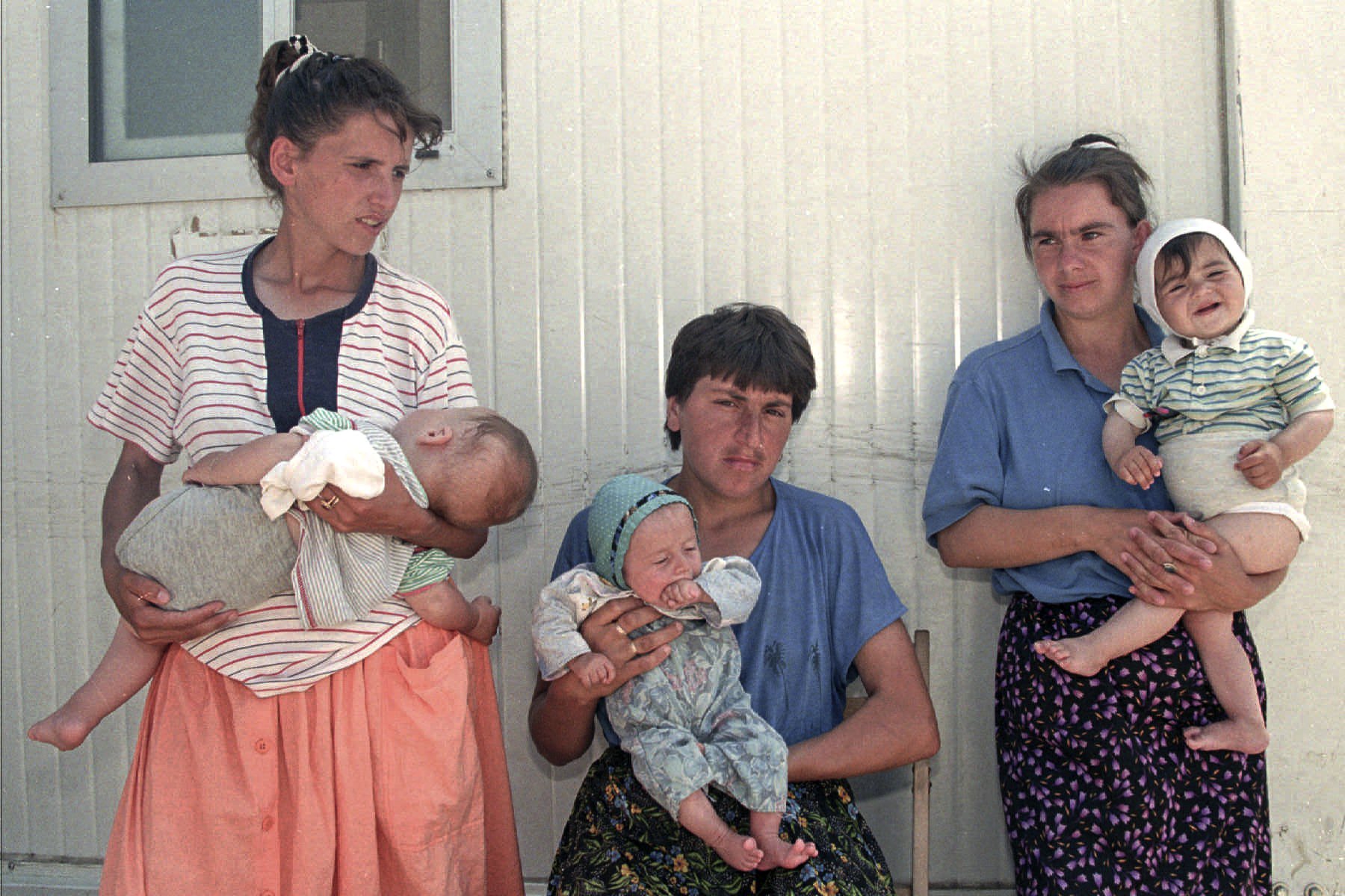 FILE- In this July 22, 1995, file picture, Bosnian refugee women from the area of Srebrenica line up waiting to bathe their babies at the UNICEF baby wash room at the U.N. air base, in Tuzla, Bosnia.  Survivors of the genocide in the eastern Bosnian town of Srebrenica, mainly women, will on Saturday July 11, 2020, commemorate the 25th anniversary of the slaughter of their fathers and brothers, husbands and sons.  At least 8,000 mostly Muslim men and boys were chased through woods in and around Srebrenica by Serb troops in what is considered the worst carnage of civilians in Europe since World War II. The slaughter was also the only atrocity of the brutal war that has been confirmed an act of genocide.(AP Photo/Michel Euler, File)