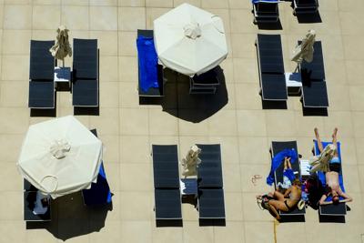 Una familia disfruta de sus vacaciones en la piscina del hotel Nissi Blue en el complejo sureño de Ayia Napa, en la isla mediterránea de Chipre, el sábado 22 de mayo de 2021. (AP Foto/Petros Karadjias)