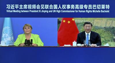 In this photo released by Xinhua News Agency, A screen showing Chinese President Xi Jinping, right, holds a virtual meeting with United Nations High Commissioner for Human Rights Michelle Bachelet, Wednesday, May 25, 2022. Xi defended China's record to the top U.N. human rights official Wednesday, saying each nation should be allowed to find its own path based on its particular circumstances and criticizing those countries that lecture others on human rights and politicize the issue. (Yue Yuewei/Xinhua via AP)