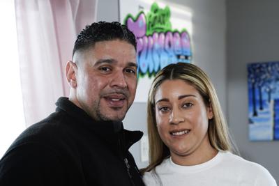 Eladio y Melissa Guzman posan para fotografías el lunes 4 de abril de 2022 en Hicksville, Nueva York. La pareja, que sufrió la guerra contra la droga, incluido un paso por la cárcel, sueña ahora con abrir una tienda de venta de marihuana para uso recreativo en Nueva York. (AP Foto/Frank Franklin II)