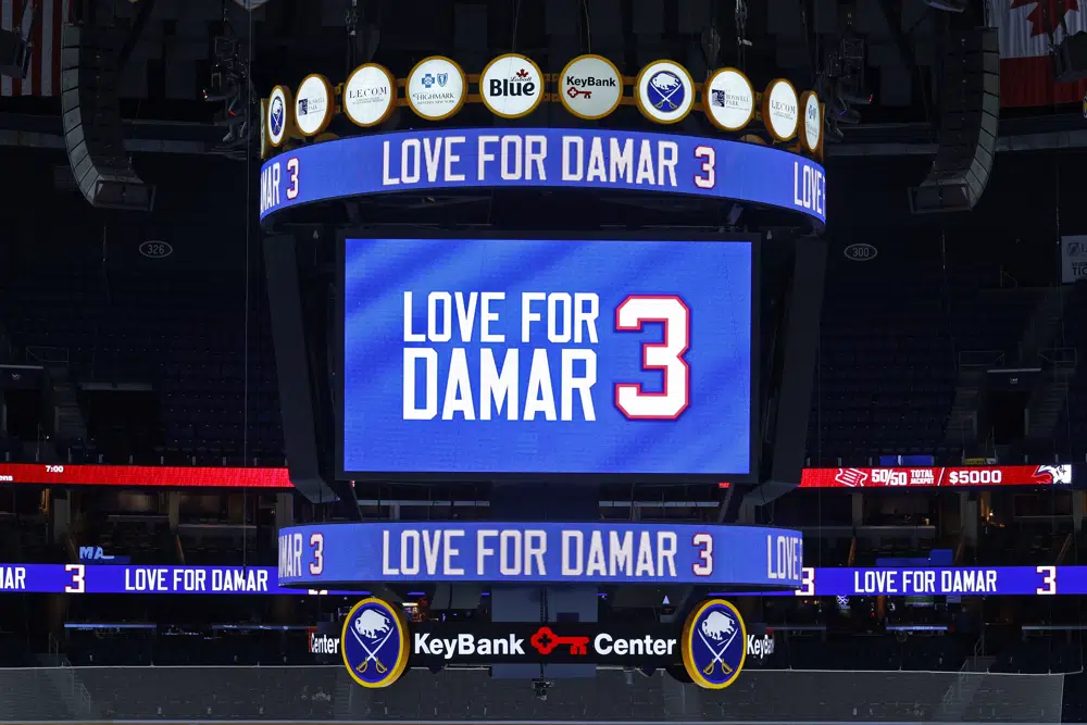 A message isdisplay on the jumbotron paying tribute to Buffalo Bills safety Damar Hamlin prior to an NHL hockey game between the Buffalo Sabres and the Minnesota Wild, Saturday, Jan. 7, 2023, in Buffalo, N.Y. (AP Photo/Jeffrey T. Barnes)