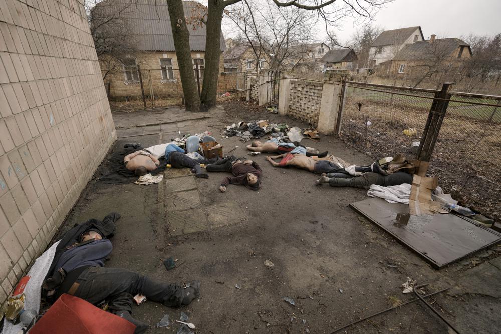 EDS NOTE: GRAPHIC CONTENT - Lifeless bodies of men, some with their hands tied behind their backs lie on the ground in Bucha, Ukraine, Sunday, April 3, 2022. Associated Press journalists in Bucha, a small city northwest of Kyiv, saw the bodies of at least nine people in civilian clothes who appeared to have been killed at close range. At least two had their hands tied behind their backs. (AP Photo/Vadim Ghirda)