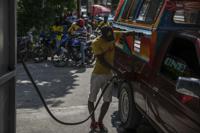 A man fills his tank at a gas station in Port-au-Prince, Haiti, Saturday, Nov. 12, 2022. Whoops of excitement echoed through the streets of Port-au-Prince early Saturday as gas stations opened across Haiti for the first time in two months after a powerful gang lifted a crippling fuel blockade. (AP Photo/Odelyn Joseph)