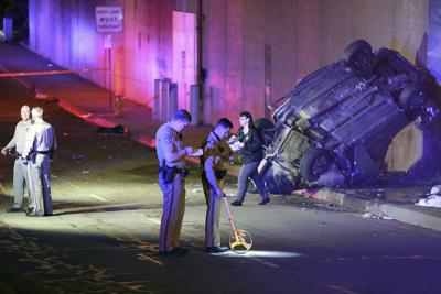 Oficiales trabajan en el lugar donde ocurrió un accidente vehicular en Pasadena, California, el 16 de enero de 2022. Tres personas murieron al caer el automóvil en el que viajaban desde una sección elevada de la autopista. (AP Foto/James Carbone)