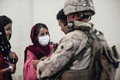 En esta imagen proporcionada por la infantería de marina de Estados Unidos, un infante de marina procesa a jóvenes antes de su evacuación en el aeropuerto internacional Hamid Karzai de Kabul, el lunes 23 de agosto de 2021. (Sargento de artillería Melissa Marnell/Infantería de Marina de Esados Unidos via AP)