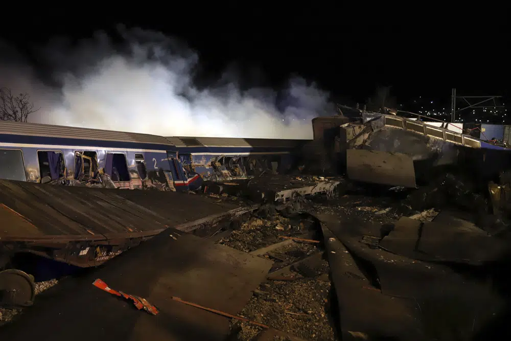 Smoke rises from trains after a collision near Larissa city, Greece, early Wednesday, March 1, 2023. The collision between a freight and passenger train occurred near Tempe, some 380 kilometers (235 miles) north of Athens, and resulted in the derailment of several train cars. (AP Photo/Vaggelis Kousioras)