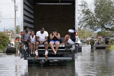 ARCHIVO - En esta imagen del lunes 30 de agosto de 2021, gente evacuada de las inundaciones provocadas por el huracán Ida en LaPlace, Luisiana. Un nuevo reporte de la agencia meteorológica de Naciones Unidas señaló que el mundo está sufriendo muchos más desastres climáticos que en la década de 1970. (AP Foto/Gerald Herbert, Archivo)