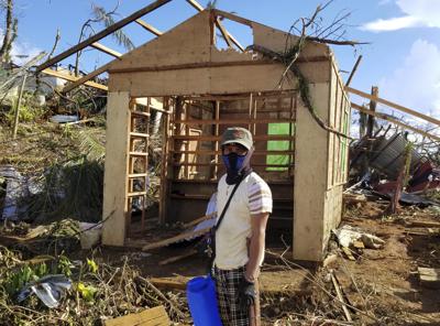 En esta foto proporcionada por la Oficina del Vicepresidente de Filipinas, un hombre revisa su casa dañada por el tifón Rai en las islas Dinagat, en el sur de Filipinas, el domingo 19 de diciembre de 2021. (Oficina del Vicepresidente de Filipinas vía AP)