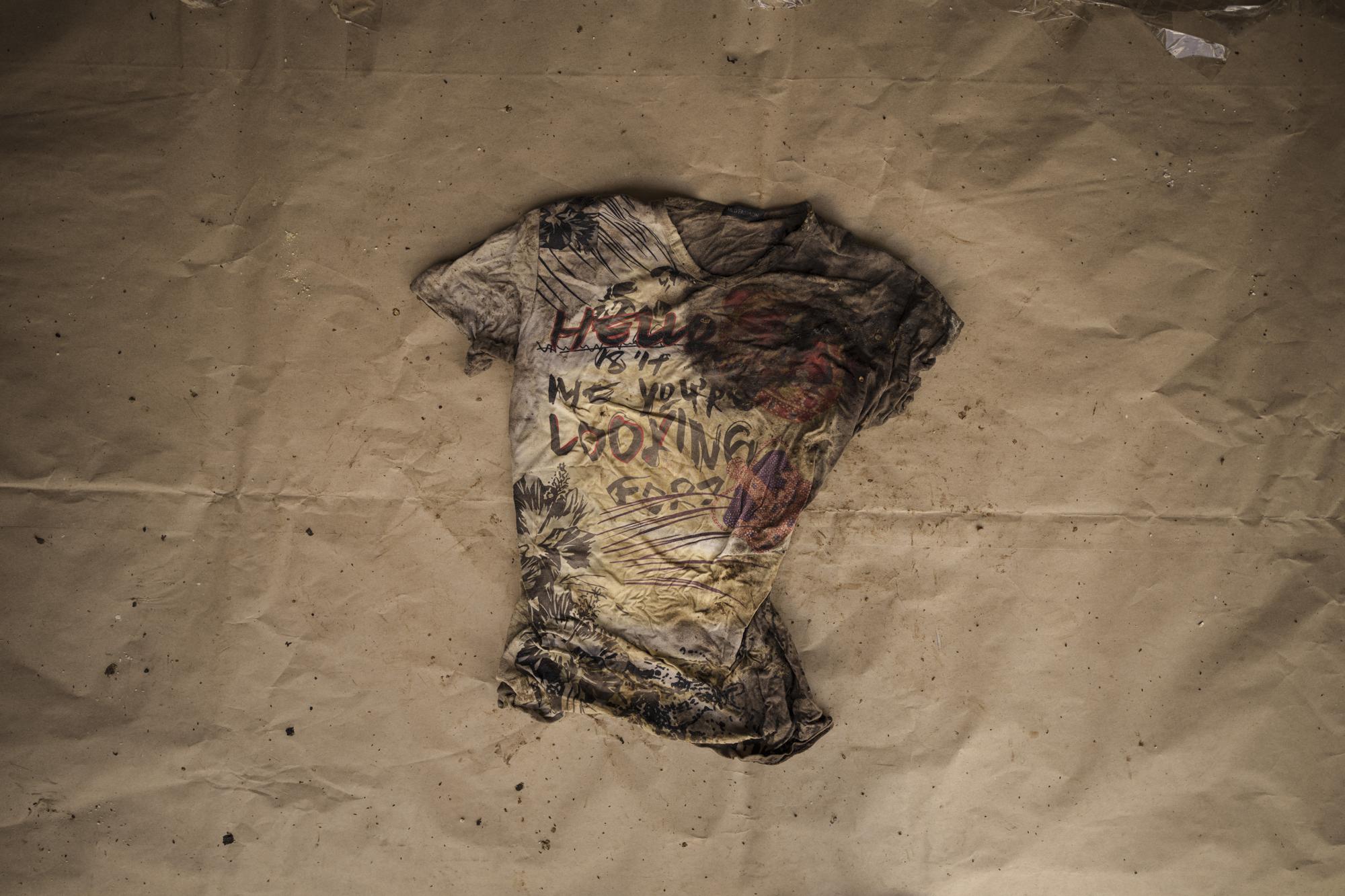 Una camiseta estampada con la frase “Hola, ¿es a mi a quién buscas?”, que llevaba uno de los migrantes muertos que aparecieron en una embarcación mauritana a la deriva el 28 de mayo de 2021, es expuesta en la comisaría de policía de Scarborough, en la isla de Tobago, en Trinidad y Tobago, el 21 de enero de 2022. (AP Foto/Felipe Dana)