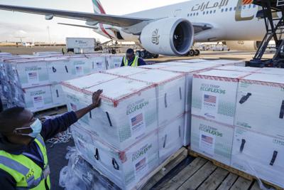 ARCHIVO - En esta imagen de archivo del lunes 23 de agosto de 2021, trabajadores del aeropuerto entre cajas con dosis de la vacuna de Moderna contra el coronavirus, donada por el gobierno de Estados Unidos a través de la iniciativa COVAX, a su llegada al aeropuerto de Nairobi, Kenia. (AP Foto/Brian Inganga, Archivo)