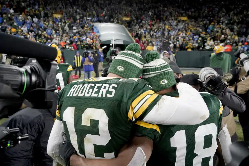 Green Bay Packers quarterback Aaron Rodgers (12) gets a hug from teammate Randall Cobb as the head off the field following an NFL football game against the Detroit Lions Sunday, Jan. 8, 2023, in Green Bay, Wis. The Lions won 20-16. (AP Photo/Morry Gash)