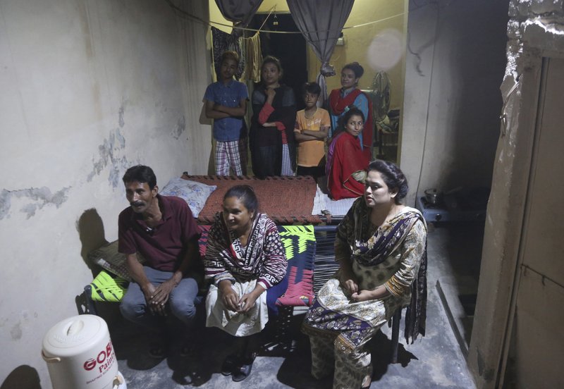 In this May 14, 2019, photo Pakistani Christian Natasha Masih, right front, sits with her family members during an interview in Faisalabad, Pakistan. Natasha begged her mother to bring her home from China, but it took an elaborate scheme devised by a small cabal of Christian men in her hometown of Faisalabad, in Pakistan's Punjab province, to orchestrate her escape from what began as an unhappy marriage, and ended in prostitution. (AP Photo/K.M. Chaudary)