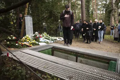 Personas se reúnen para el entierro de huesos terrenos de la Universidad Libre en Berlín, Alemania, el jueves 23 de marzo de 2023. (AP Foto/Markus Schreiber)