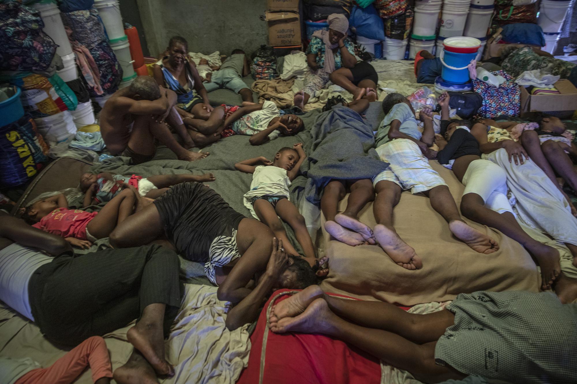 Internally displaced people due to violence sleep inside a school converted into a shelter in Port-au-Prince, Haiti, Thursday, Sept. 16, 2021. Deportees join thousands of fellow Haitians who have been displaced from their homes, pushed out by violence to take up residence in crowded schools, churches, sports centers and makeshift camps among ruins. (AP Photo/Rodrigo Abd)