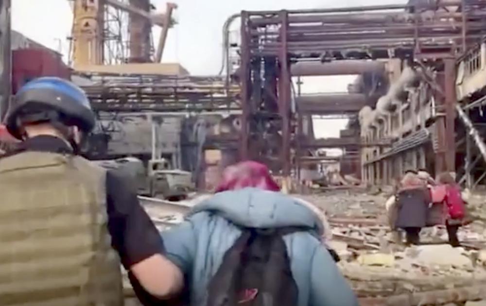 This frame taken from an undated video provided Sunday, May 1, 2022 by the Azov Special Forces Regiment of the Ukrainian National Guard shows people walking over debris at the Azovstal steel plant, in Mariupol, eastern Ukraine.  As many as 100,000 people may still be in Mariupol, including an estimated 2,000 Ukrainian fighters beneath the sprawling, Soviet-era steel plant — the only part of the city not occupied by the Russians. (Azov Special Forces Regiment of the Ukrainian National Guard via AP)