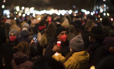 Miles de personas en Viena participan en el "mar de luces" en honor a las más de 13.000 personas que han muerto de coronavirus en Austria, el 19 de diciembre de 2021. (AP Foto/Michael Gruber)