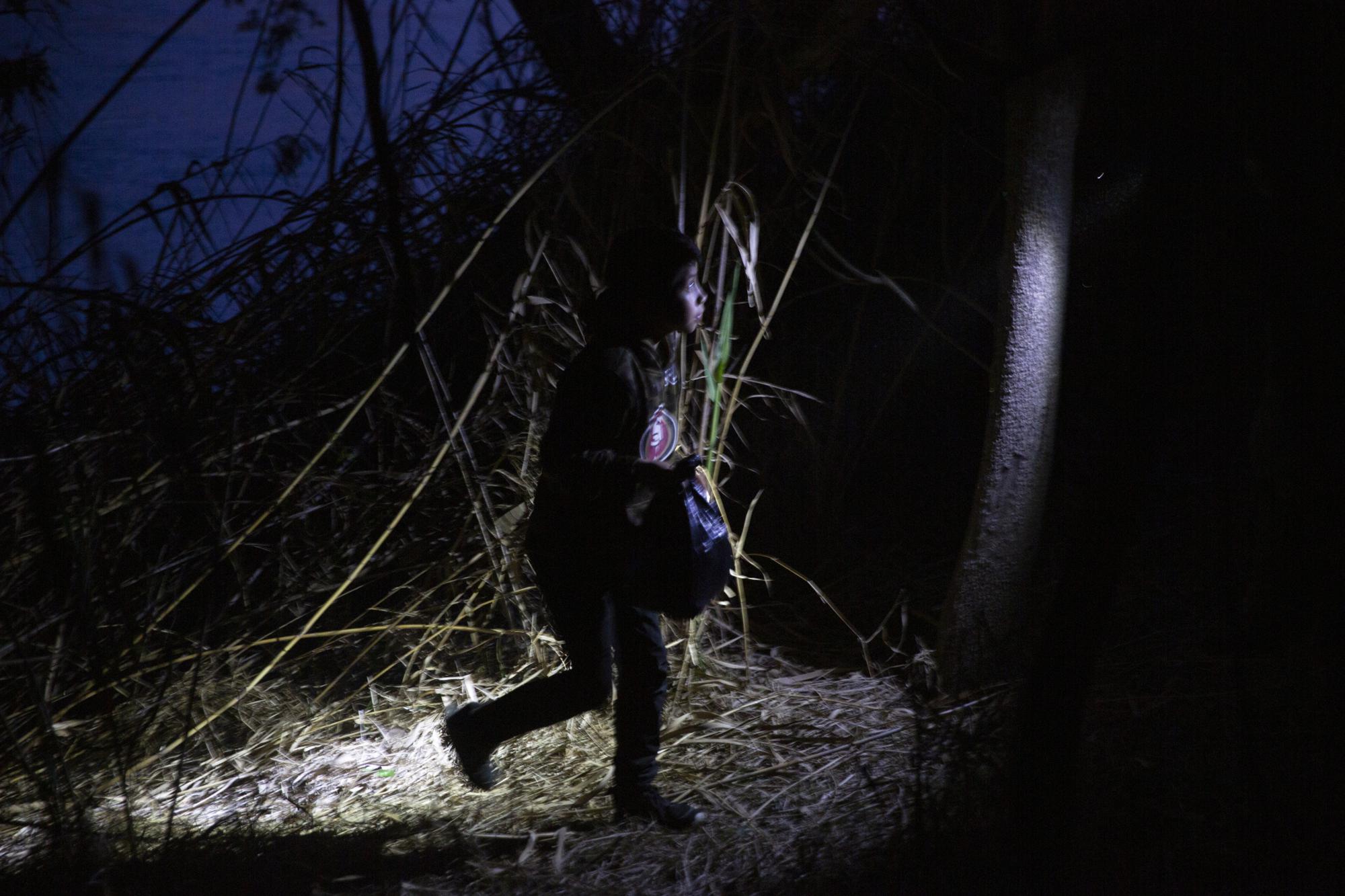 FILE - Young child walks alone through the brush after being smuggled across the Rio Grande river in Roma, Texas, March 24, 2021. Children traveling alone shattered previous highs in March, making up most of the more than 4,500 people housed in temporary tents that were designed for 250 under COVID-19 standards. (AP Photo/Dario Lopez-Mills, File)