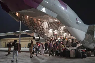 Los evacuados que salen de Sudán desembarcan de un C-17 Globemaster qatarí en la Base Aérea Al Udeid, Qatar, el sábado 6 de mayo de 2023. Qatar realizó un vuelo de socorro a Sudán, transportando unas 40 toneladas de alimentos y saliendo con 150 evacuados el sábado temprano mientras continúan los combates entre dos generales que compiten por el poder en la nación africana. (AP Photo/Lujain Jo)