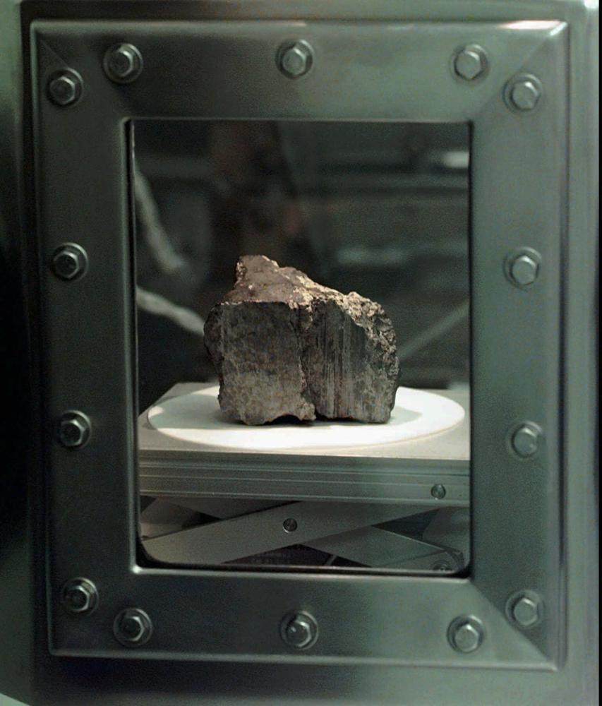 El meteorito etiquetado ALH84001 se encuentra en una cámara en un laboratorio del Centro Espacial Johnson en Houston, el 7 de agosto de 1996. Los científicos dicen que han confirmado que el meteorito de Marte no contiene evidencia de vida marciana antigua.  La roca causó revuelo hace 25 años cuando un equipo dirigido por la NASA anunció que sus compuestos orgánicos podrían haber sido dejados por criaturas vivas, por primitivas que fueran.  Los investigadores socavaron esa teoría durante décadas.  Un equipo de científicos dirigido por Andrew Steele de la Institución Carnegie publicó sus hallazgos el jueves 13 de enero de 2022. (Foto AP/David J. Phillip)