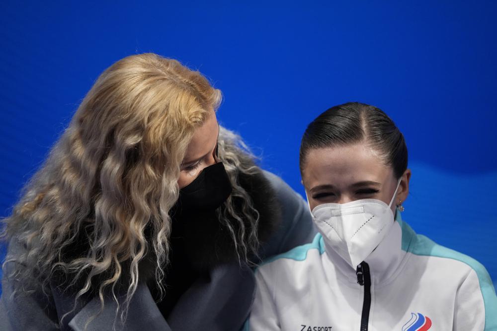 La entrenadora Eteri Tutberidze, a la izquierda, se sienta con Kamila Valieva, del Comité Olímpico Ruso, después del programa corto femenino durante el patinaje artístico en los Juegos Olímpicos de Invierno de 2022, el martes 15 de febrero de 2022 en Beijing.  (Foto AP/Natacha Pisarenko)