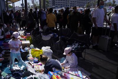 Varias familias _en su mayoría rusas_ que buscan asilo en Estados Unidos acampan el jueves 17 de marzo de 2022 en Tijuana, México, frente al paso fronterizo de San Ysidro. (AP Foto/Gregory Bull)
