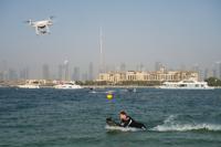 FILE - A drone follows a man riding a motorized surfboard in Dubai, United Arab Emirates, June 25, 2020. The UAE has banned the flying of drones in the country for recreation after Yemen’s Houthi rebels claimed a fatal drone attack on an oil facility and major airport in the country. As of Saturday, Jan. 22, 2022, drone hobbyists and other operators of light electric sports aircraft face “legal liabilities” if caught flying the objects, the Interior Ministry said, adding it may grant exemptions to businesses seeking to film. (AP Photo/Jon Gambrell, File)