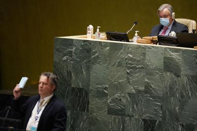 El secretario general de la ONU António Guterres, derecha al fondo, observa mientras el embajador de Ucrania, Sergiy Kyslytsya, muestra un ejemplar de la carta de las Naciones Unidas, el miércoles 2 de marzo de 2022, en una sesión de emergencia de la Asamblea. (AP Foto/Seth Wenig)