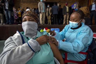 Fotografía de archivo del viernes 1 de octubre de 2021 de una mujer recibiendo su segunda dosis de la vacuna de Pfizer-BioNTech de una trabajadora de salud durante una campaña de vacunación en Katlehong, este de Johannesburgo, en Sudáfrica. (AP Foto/Themba Hadebe, Archivo)