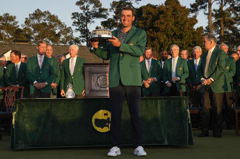 Scottie Scheffler holds the championship trophy after winning the 86th Masters golf tournament on Sunday, April 10, 2022, in Augusta, Ga. (AP Photo/David J. Phillip)
