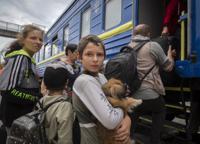 A boy holds his pet dog as his family evacuated from the war-hit area gets on an evacuation train in Pokrovsk, eastern Ukraine, Saturday , June 25, 2022. (AP Photo/Efrem Lukatsky)