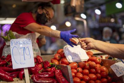 ARCHIVO - Un cliente compra verduras en el mercado Maravillas de Madrid, el 12 de mayo de 2022. (AP Foto/Manu Fernández, archivo)