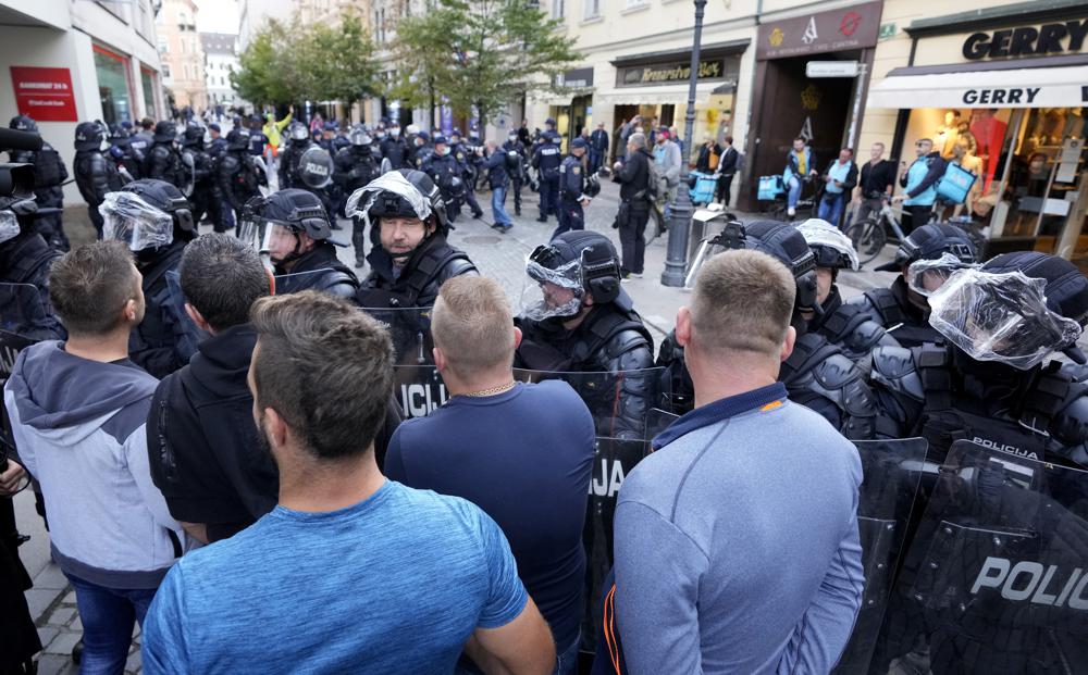 FILE - Police form a line against demonstrators during a protest against vaccinations and coronavirus measures in Ljubljana, Slovenia, Tuesday, Oct. 5, 2021. Slovenian Interior minister Ales Hojs on Friday, Oct. 8, 2021 rejected accusations that police used excessive force to curb anti-government protests with water cannons and tear gas on the eve of a major European Union summit in the country earlier this week.  (AP Photo/Petr David Josek, file)