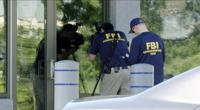 In this still image taken from WKEF/WRGT video, members of the FBI Evidence Response Team work outside the FBI building in Kenwood, Ohio, Thursday, Aug. 11, 2022. An armed man decked out in body armor tried to breach a security screening area at an FBI field office in Ohio on Thursday, then fled and was injured in an exchange of gunfire in a standoff with law enforcement, authorities said. (Courtesy WKEF/WRGT via AP)