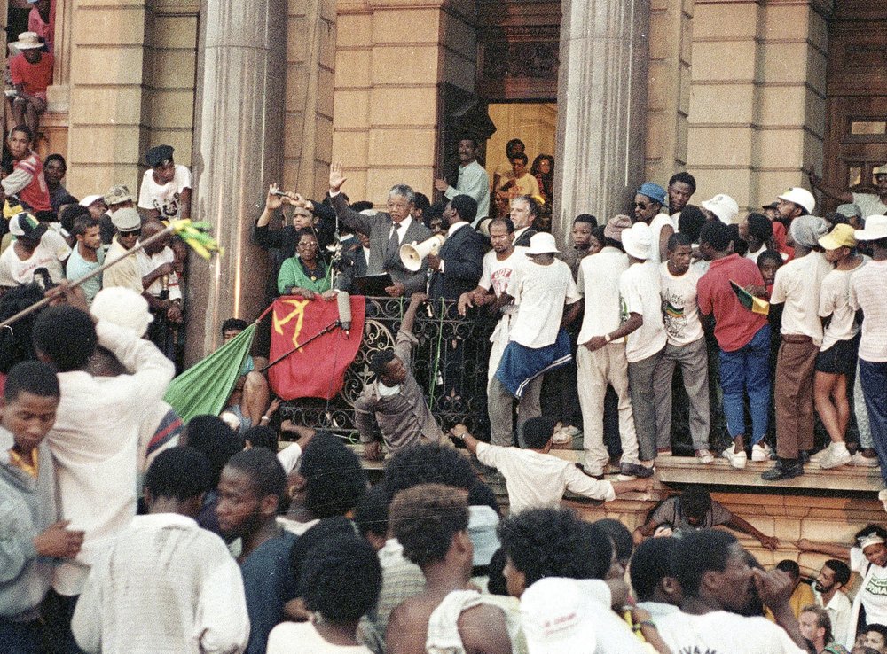 FILE - In this Feb. 11, 1990 file photo, Nelson Mandela, gestures as he addresses supporters at the Cape Town, South Africa City Hall after his release from 27 years in prison. Tuesday, Feb. 11, 2020 marks the 30 year anniversary of the release of the former South African president. (AP Photo/Udo Weitz, File)