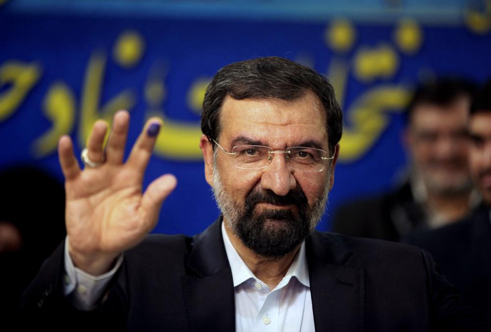 FILE - Mohsen Rezaei waves to reporters after registering as a presidential candidate, in Tehran, Iran, May 10, 2013. Argentina’s Foreign Ministry said Tuesday, Jan. 11, 2022, that the appearance of Rezaei, at the investiture of Nicaragua’s president on Monday was “an affront to Argentine justice and to the victims of the brutal terrorist attack″.  Rezaei, a former leader of Iran’s paramilitary Revolutionary Guard, is wanted by Argentina on an Interpol “Red Notice” alleging he was involved in the 1994 bombing of a Jewish center in Buenos Aires that killed 85 people.  (AP Photo/Vahid Salemi, File)