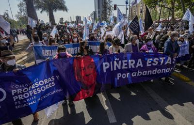 ARCHIVO - Maestros en huelga llevan una pancarta que representa al presidente de Chile, Sebastián Piñera, mientras piden su renuncia porque su nombre figura en los Papeles de Pandora en Santiago, Chile, el miércoles 13 de octubre de 2021. Una comisión rechazó el viernes 5 de noviembre de 2021 el juicio político a Piñera, que ahora será votado por la Cámara de Diputados, por la supuesta venta de una propiedad familiar en un paraíso fiscal.  (AP Foto / Esteban Felix, Archivo)