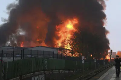 Grandes llamas se alzan de un incendio en Hamburgo, Alemania, el domingo 9 de abril de 2023.La policía advirtió a la gente en Hamburgo, Alemania, que cerrase las ventanas el domingo por la mañana después de que un gran incendio en varios almacenes provocara una negra humareda con sustancias químicas sobre la ciudad. (Jonas Walzberg/dpa via AP)