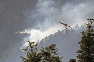 Fotografía del Servicio Forestal de Estados Unidos de aviones conocidos como "super scoopers" combatiendo los incendios Hermits Peak y Calf Canyon en el Bosque Nacional Santa Fe en Nuevo México, el martes 26 de abril de 2022. (J. Michael Johnson/U.S. Forest Service vía AP)